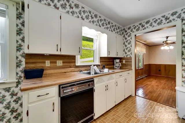a kitchen with granite countertop a sink stainless steel appliances and cabinets