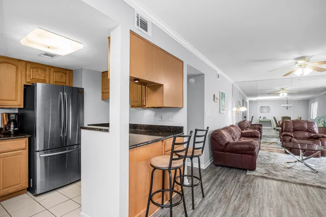 a kitchen with stainless steel appliances granite countertop a refrigerator a stove and a sink with wooden floor