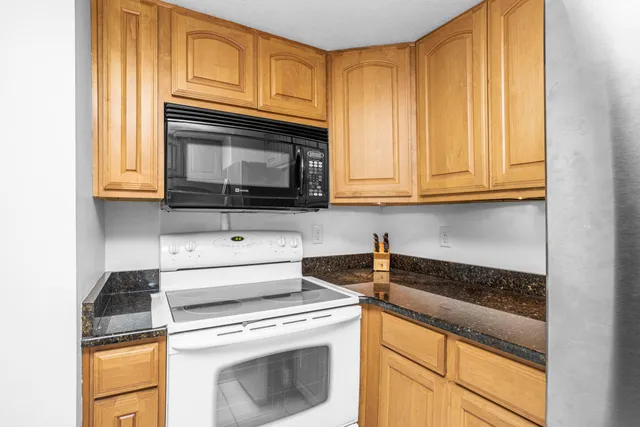 a kitchen with granite countertop cabinets stainless steel appliances and a counter space