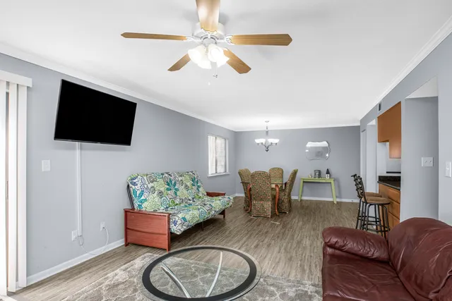 a living room with furniture a flat screen tv and kitchen view