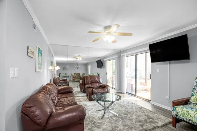 a living room with furniture a ceiling fan and a window