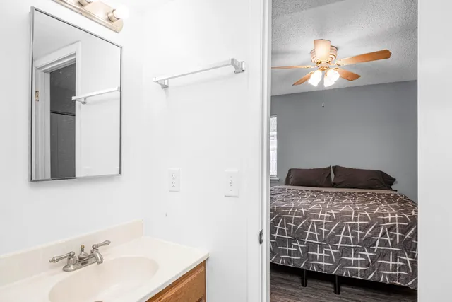 a bedroom with a bed and a large mirror on the dresser