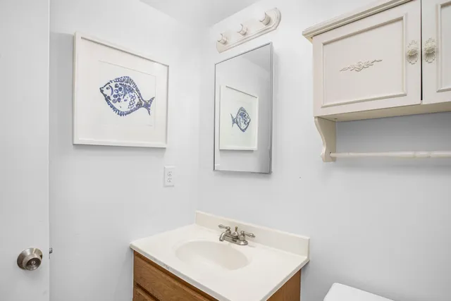 a bathroom with a sink and mirror with toilet