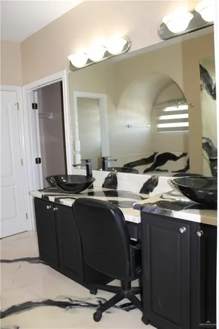 a kitchen with a sink a cabinets and chairs