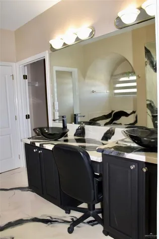 a kitchen with a sink a cabinets and chairs