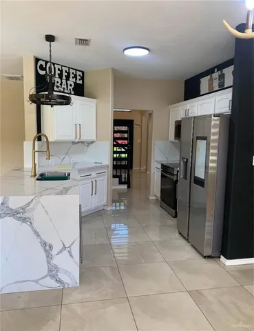 a kitchen with granite countertop a refrigerator and a sink