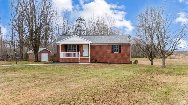 a white house with a large tree and yard