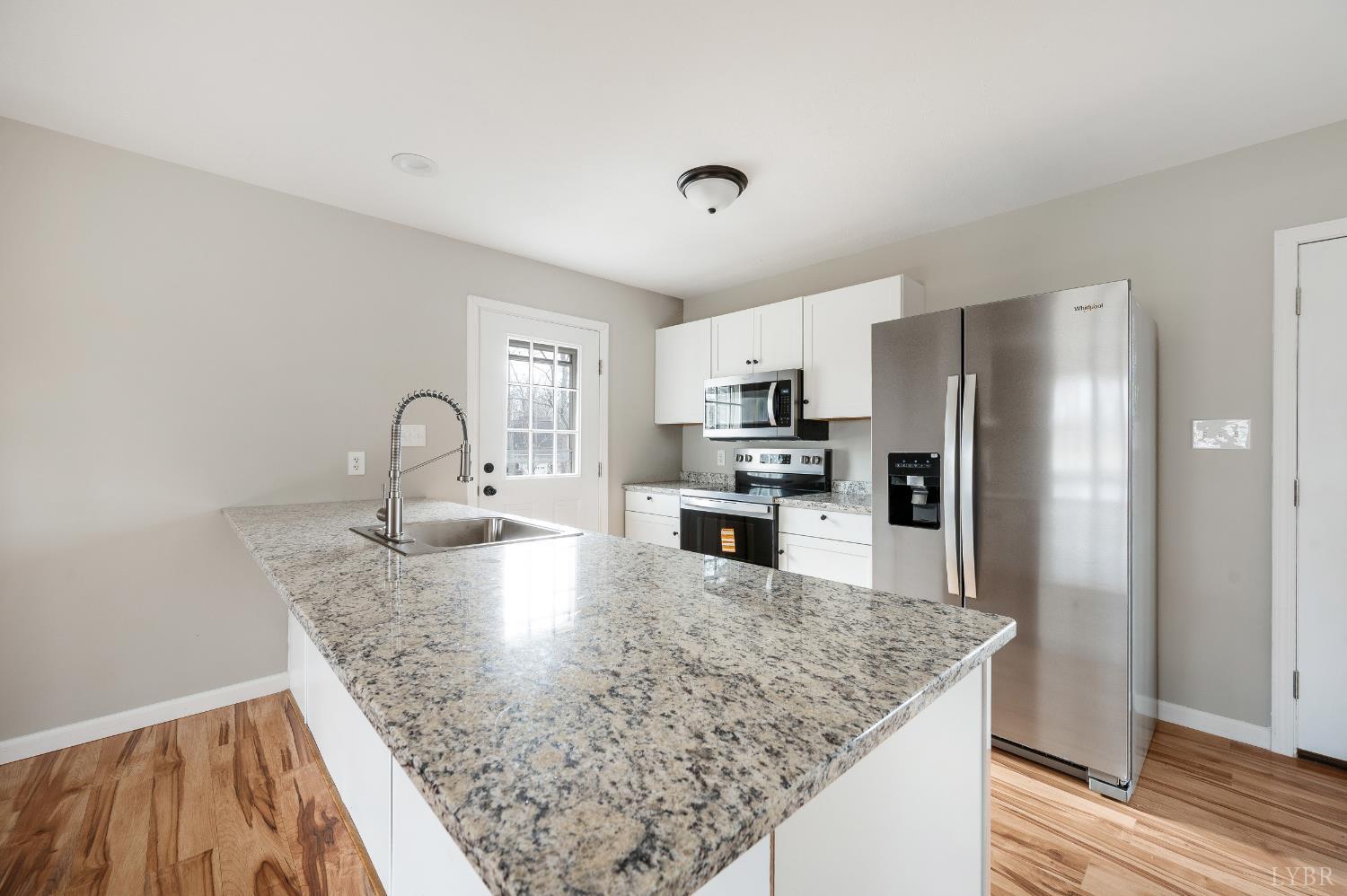 2365 Police Tower Road Appomattox, VA 24522 - Photo 12 of 52 a kitchen with stainless steel appliances granite countertop a sink refrigerator and microwave