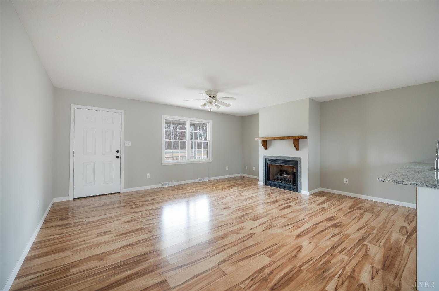 2365 Police Tower Road Appomattox, VA 24522 - Photo 7 of 52 a view of empty room with wooden floor fireplace and windows