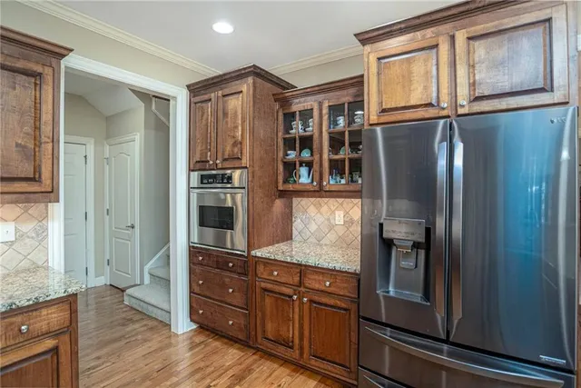 a kitchen with stainless steel appliances granite countertop a refrigerator and a stove top oven