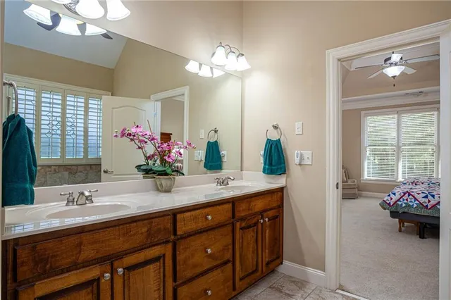 a spacious bathroom with a granite countertop sink a large mirror and a window