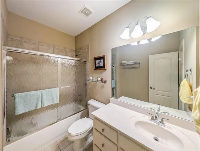 a bathroom with a sink a toilet a mirror a vanity and shower