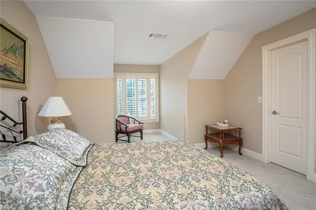 a bedroom with a bed and a lamp on dresser