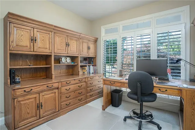 a view of a workspace with furniture and a window