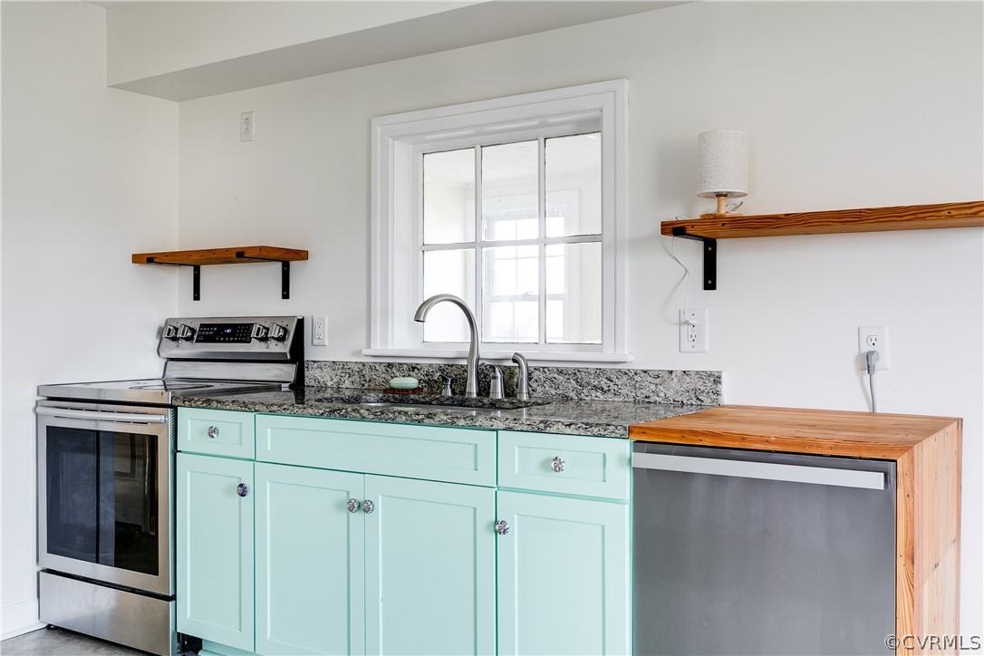 4109 Whitehall Road Sandy Hook, VA 23153 - Photo 8 of 28 a kitchen with stainless steel appliances granite countertop a sink stove and cabinets