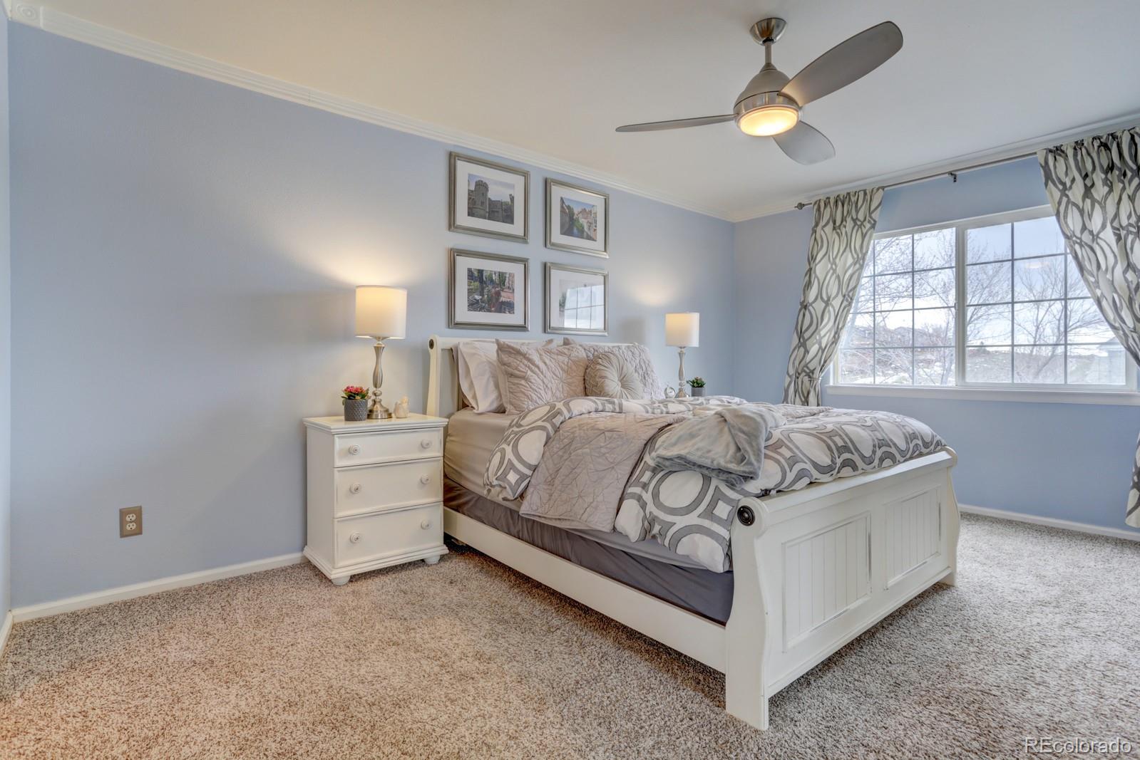 801 Riddlewood Lane Highlands Ranch, CO 80129 - Photo 17 of 40 a bedroom with a bed and a chandelier