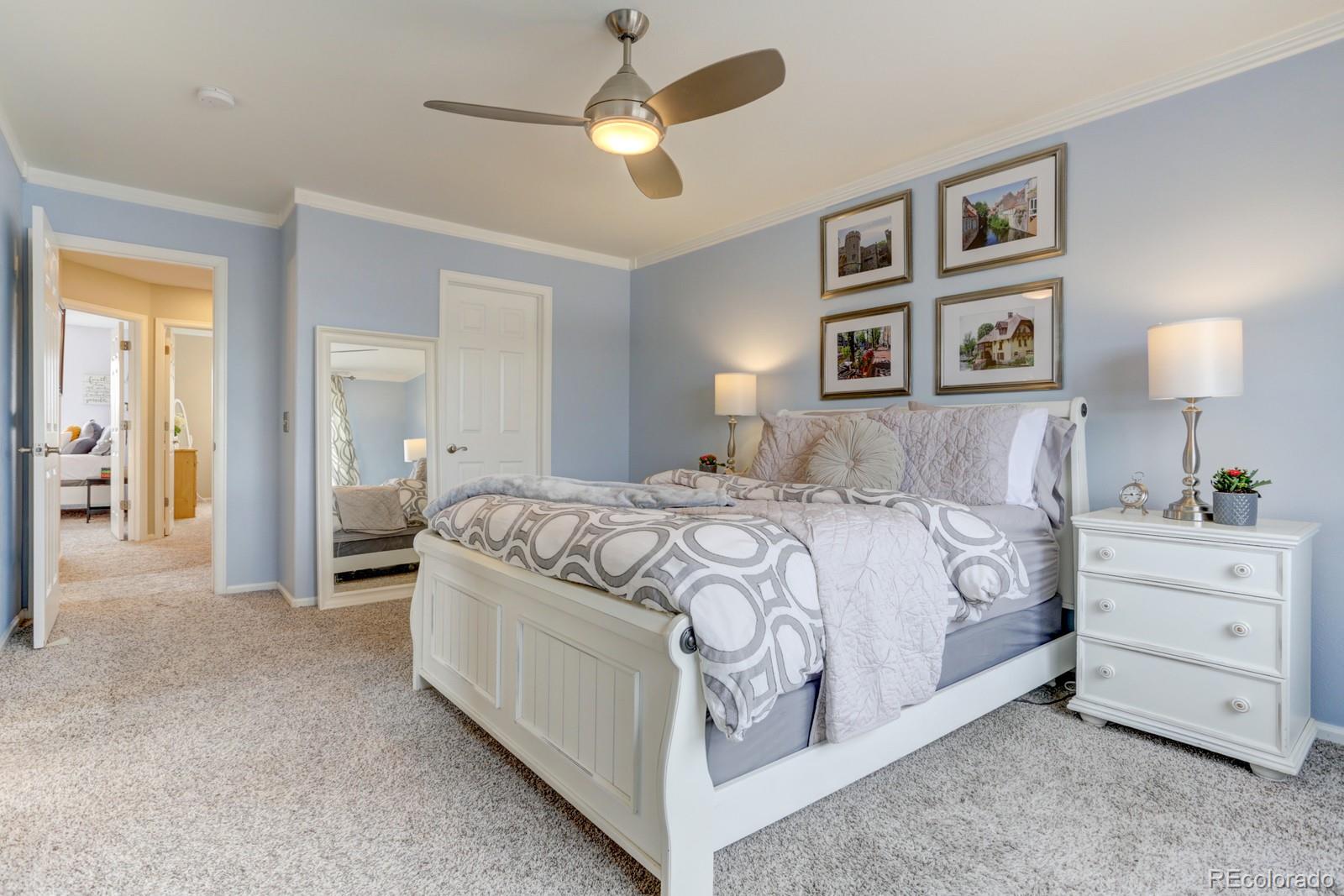 801 Riddlewood Lane Highlands Ranch, CO 80129 - Photo 18 of 40 a spacious bedroom with a bed and a chandelier