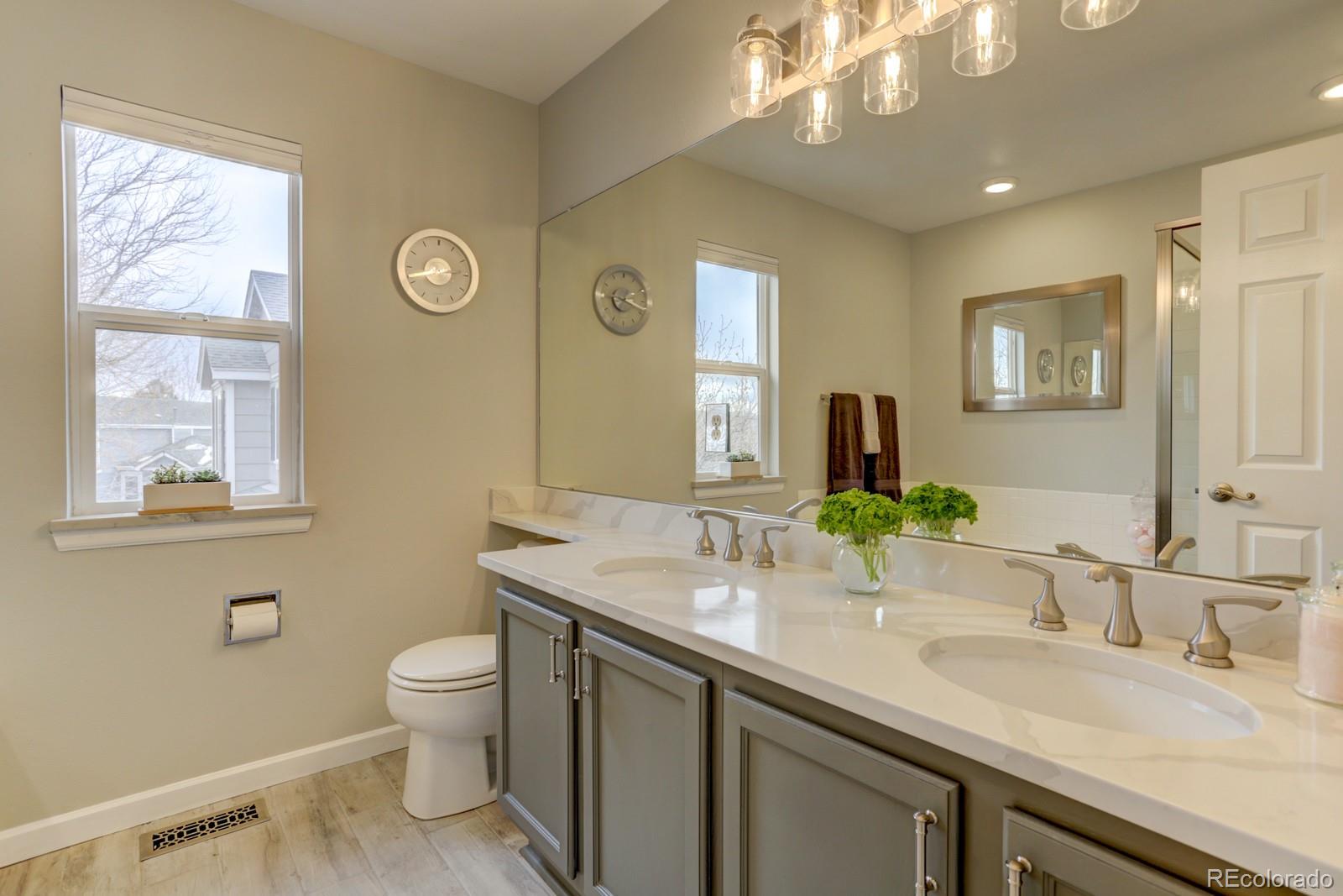 801 Riddlewood Lane Highlands Ranch, CO 80129 - Photo 20 of 40 a bathroom with a granite countertop sink a large mirror and a toilet