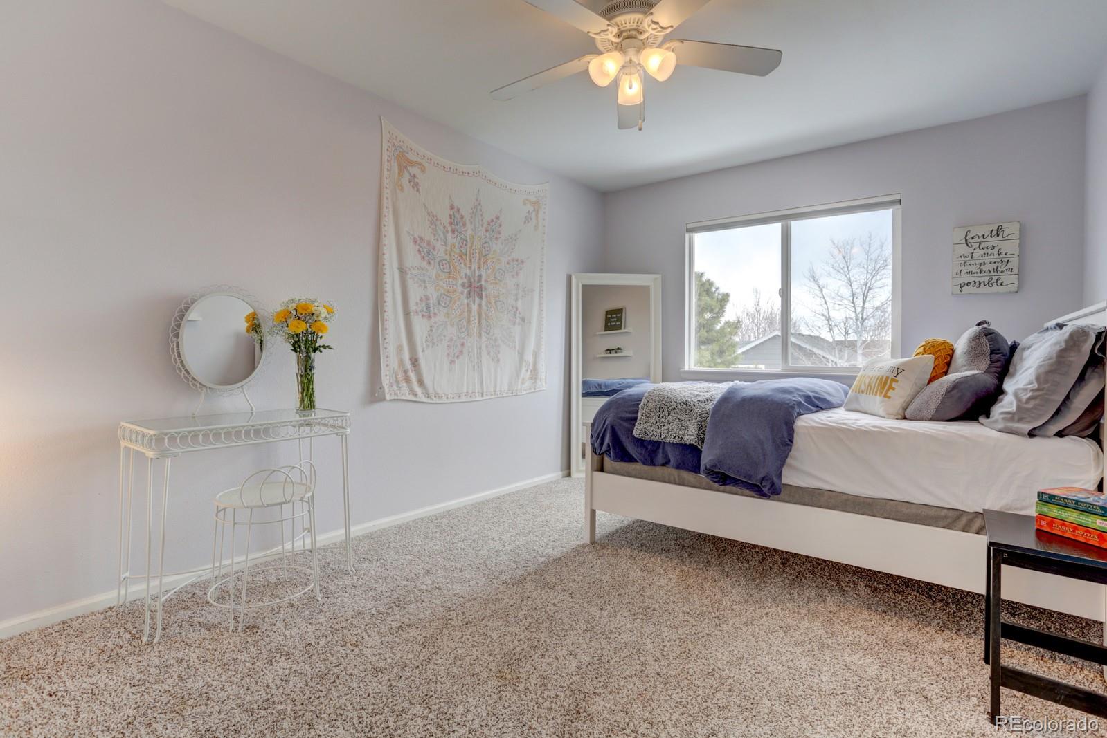 801 Riddlewood Lane Highlands Ranch, CO 80129 - Photo 22 of 40 a spacious bedroom with a bed and window