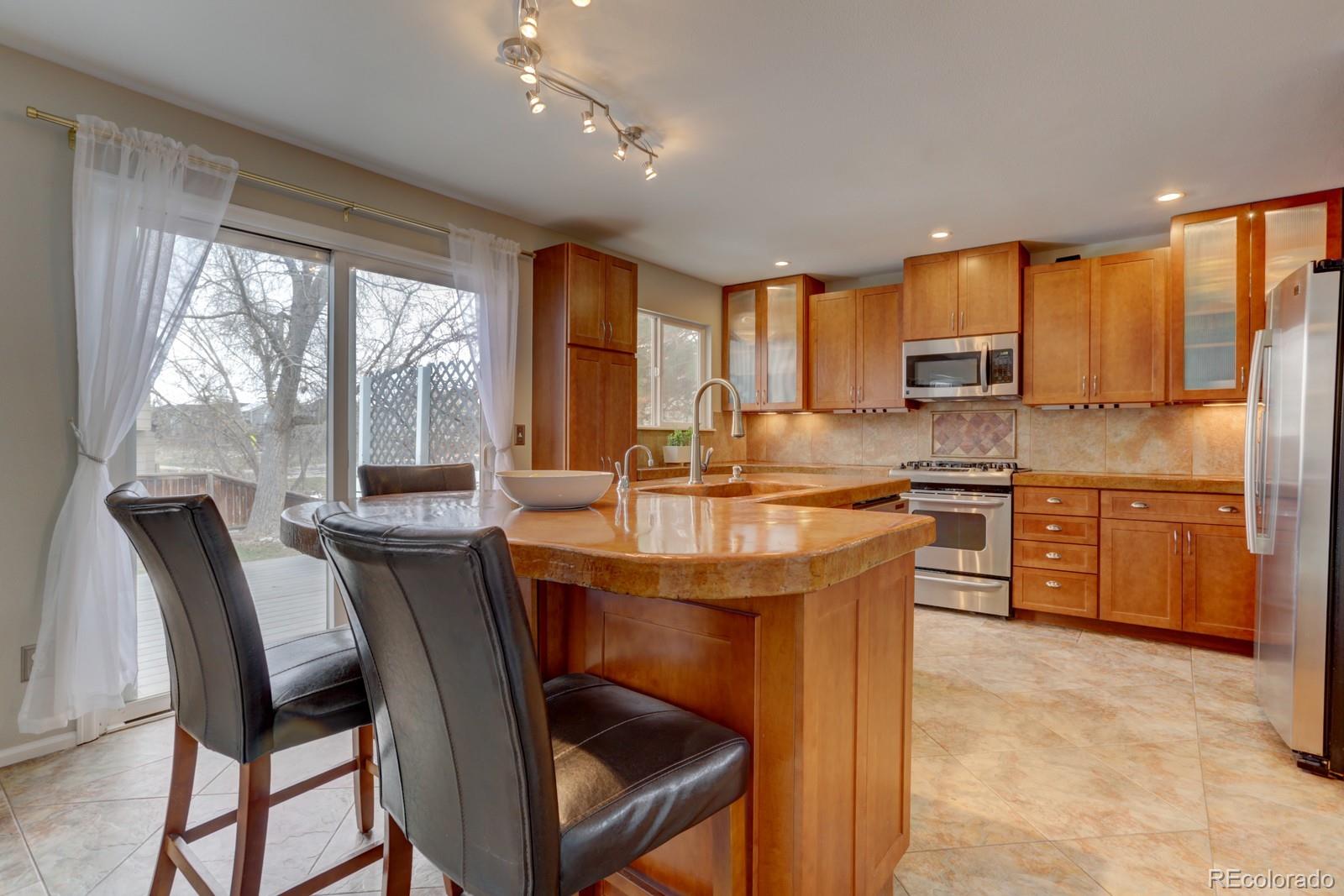801 Riddlewood Lane Highlands Ranch, CO 80129 - Photo 6 of 40 a kitchen with a table chairs sink microwave and cabinets