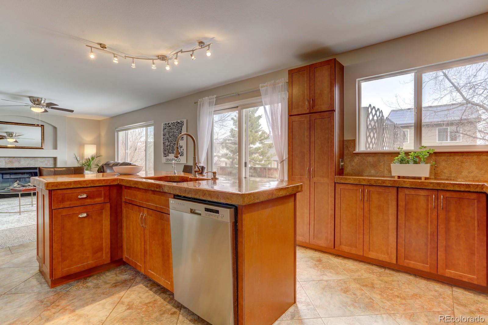 801 Riddlewood Lane Highlands Ranch, CO 80129 - Photo 9 of 40 a kitchen with stainless steel appliances granite countertop wooden cabinets a sink and a large window