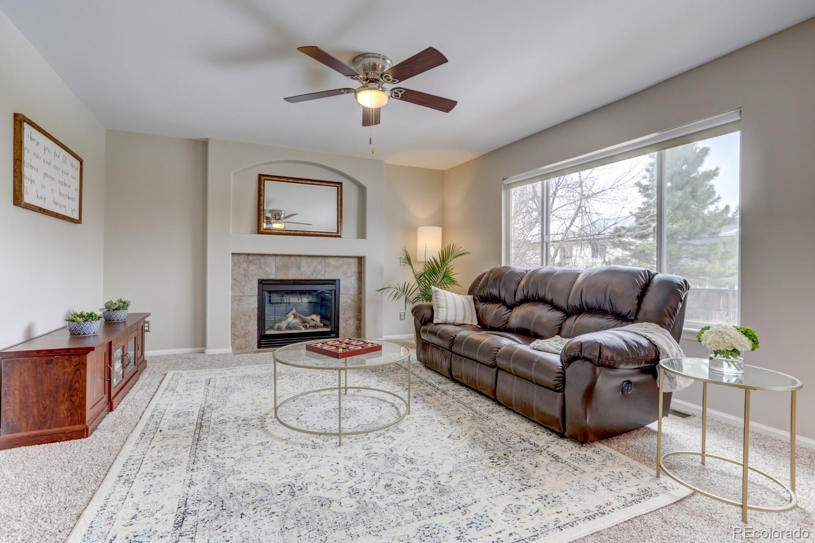 801 Riddlewood Lane Highlands Ranch, CO 80129 - Photo 10 of 40 a living room with furniture a window and a fireplace