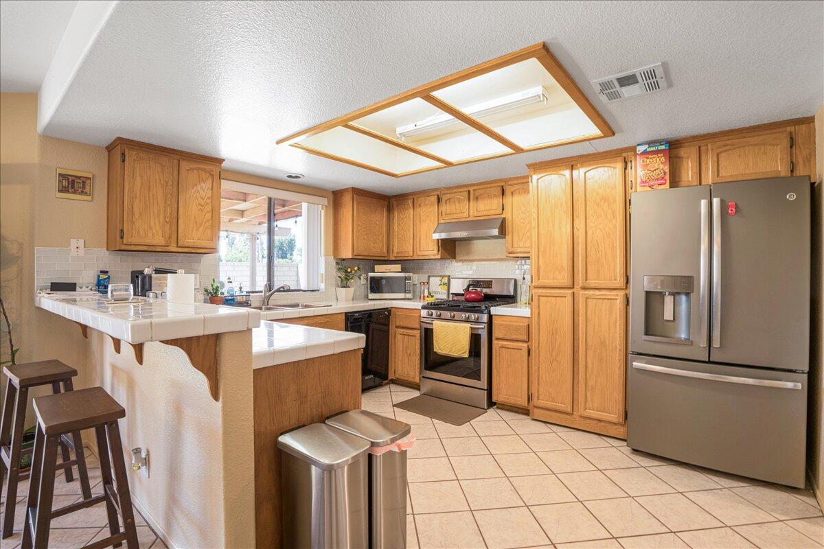 81033 Jamie Way Indio, CA 92201 - Photo 11 of 27 a kitchen with a refrigerator a sink cabinets and a window