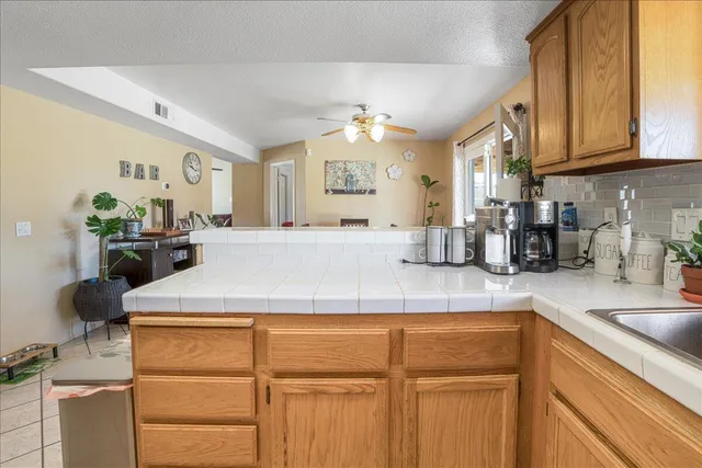 a kitchen with kitchen island granite countertop a sink cabinets and wooden floor