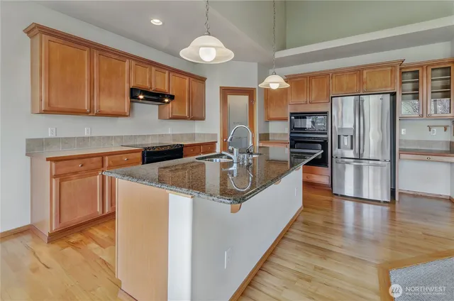 a kitchen with stainless steel appliances granite countertop a sink stove and refrigerator