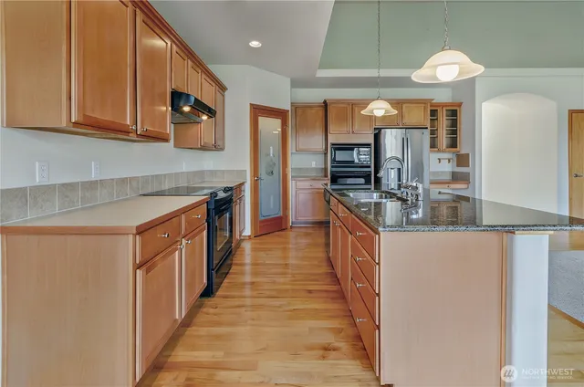 a kitchen with stainless steel appliances granite countertop a stove and cabinets