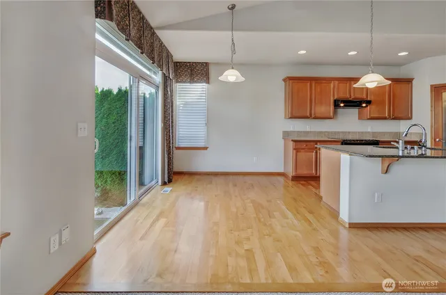 a view of a kitchen with kitchen island a counter top space a sink and appliances