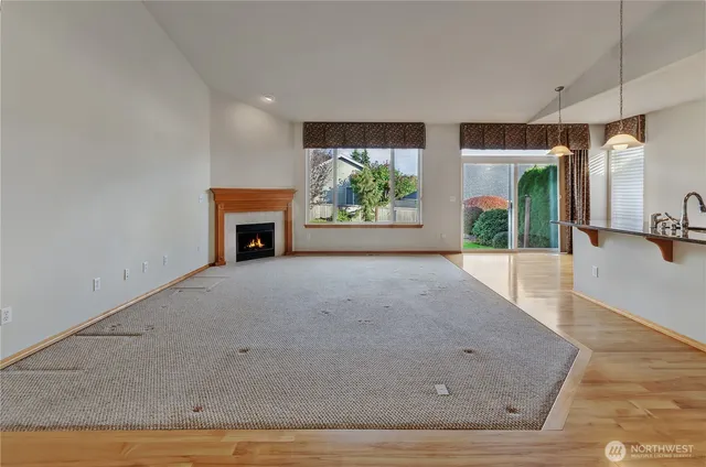 an empty room with windows and fireplace
