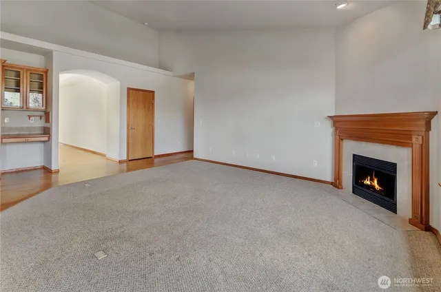 a view of an empty room with fireplace and a window