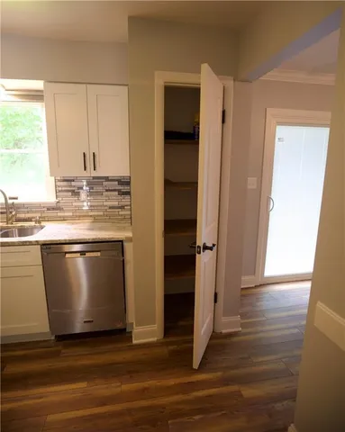 a view of kitchen with granite countertop a stove and a wooden floor
