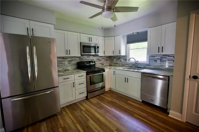 a kitchen with stainless steel appliances a refrigerator sink and microwave