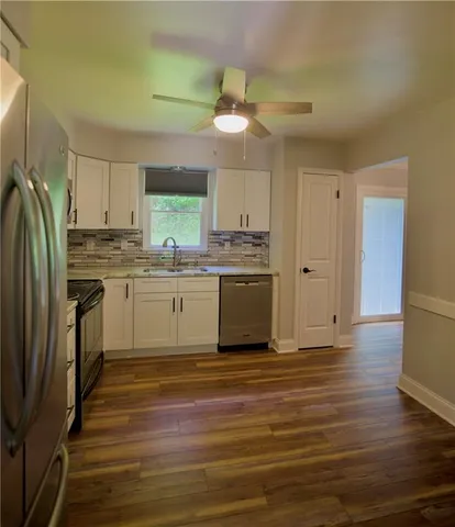 a kitchen with stainless steel appliances granite countertop a stove top oven a refrigerator and a sink