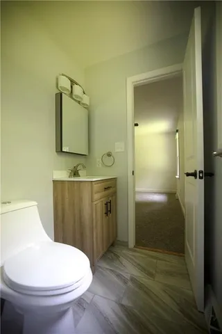 a bathroom with a toilet a sink and mirror