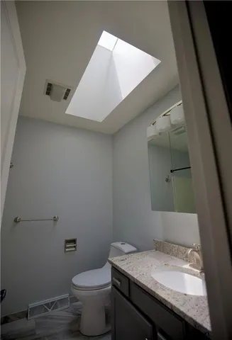 a bathroom with a granite countertop sink toilet and vanity