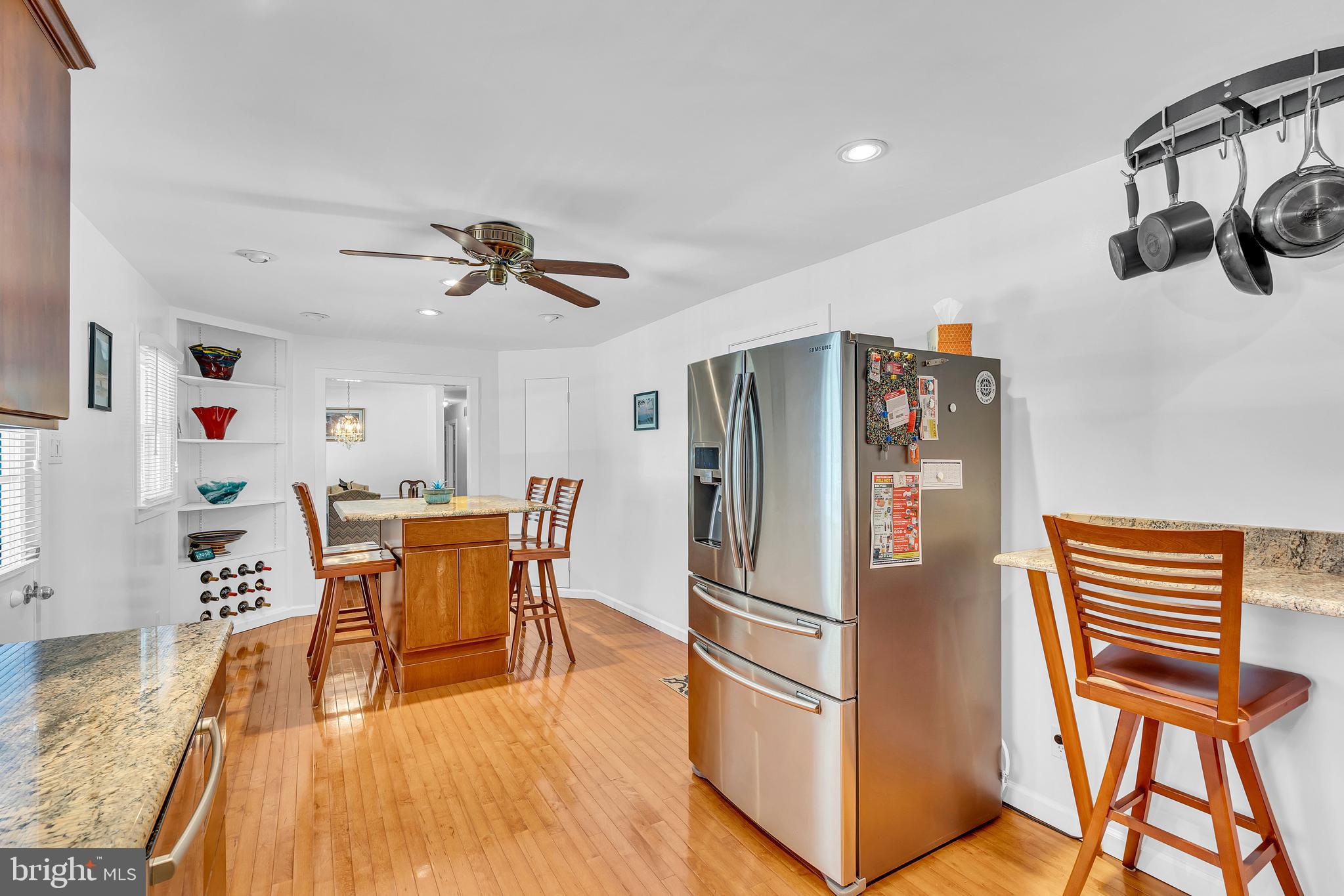 6 Park Road Mount Holly, NJ 08060 - Photo 22 of 58 a kitchen with stainless steel appliances a refrigerator a stove a dining table and chairs with wooden floor