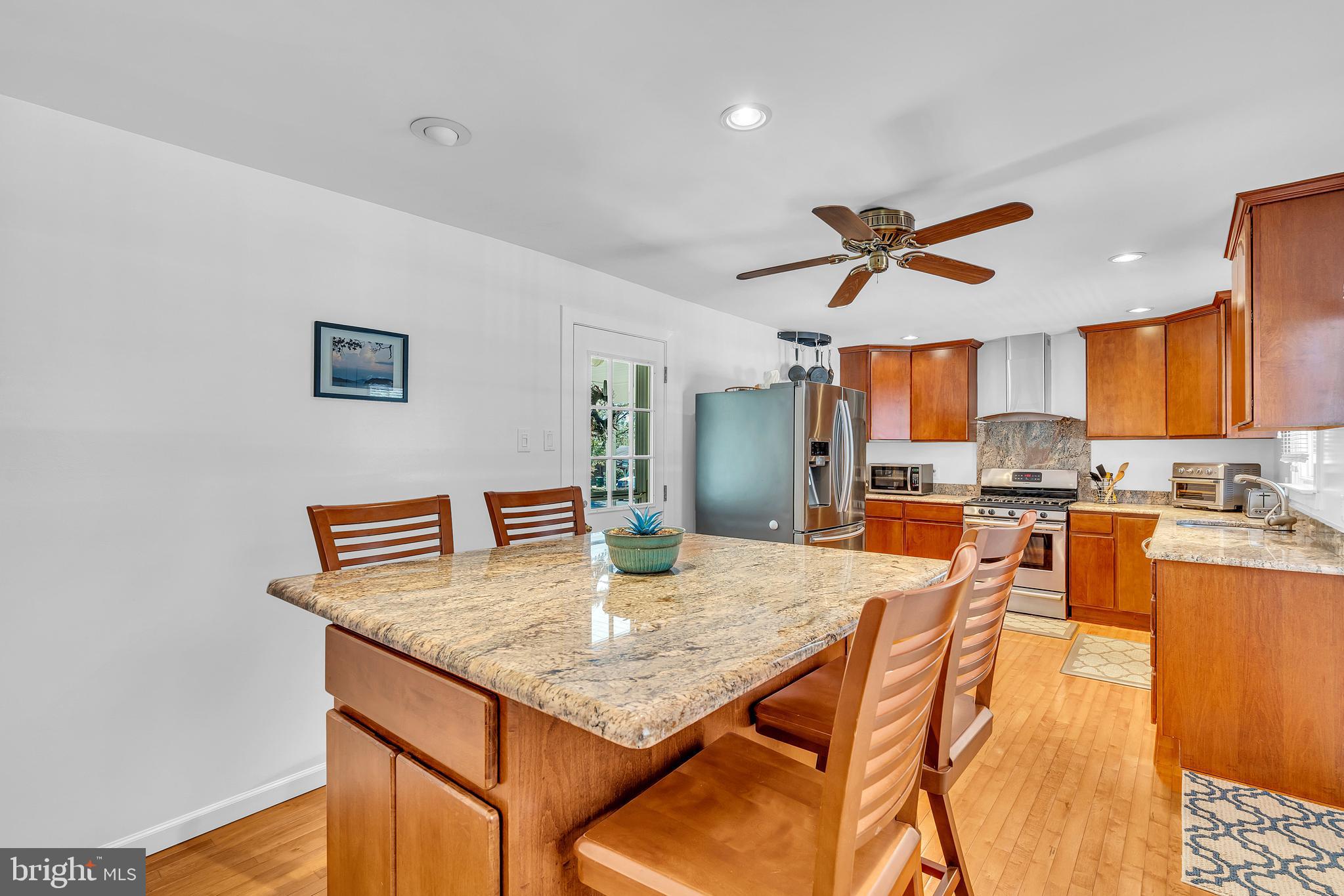 6 Park Road Mount Holly, NJ 08060 - Photo 26 of 58 a kitchen with stainless steel appliances kitchen island granite countertop a table chairs in it and wooden floors