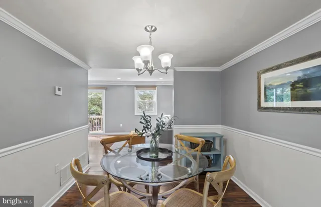 a dining room with furniture a chandelier and wooden floor