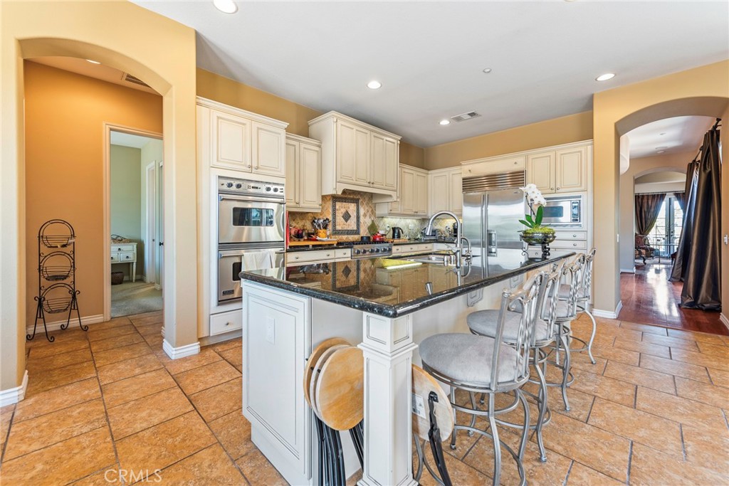 7940 Choi Drive Riverside, CA 92506 - Photo 21 of 56 a kitchen with stainless steel appliances kitchen island granite countertop a sink and cabinets