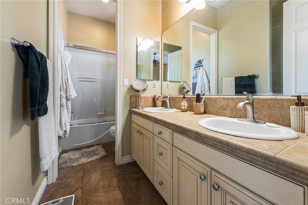 7940 Choi Drive Riverside, CA 92506 - Photo 42 of 56 a bathroom with a double vanity sink a mirror and a shower