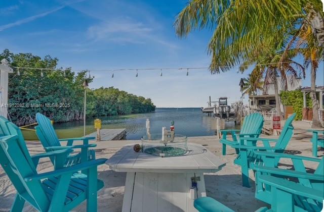 325 Calusa Street, Unit 118 Key Largo, FL 33037 - Photo 13 of 18 a view of backyard of house with seating space and trees in the background
