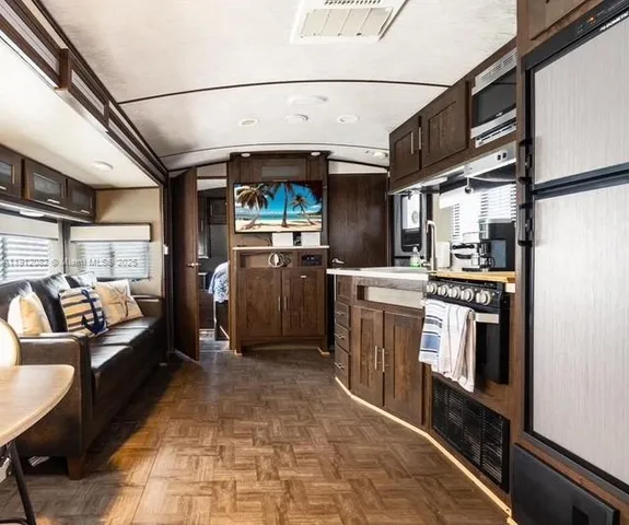 a kitchen with stainless steel appliances granite countertop a refrigerator a stove and a sink