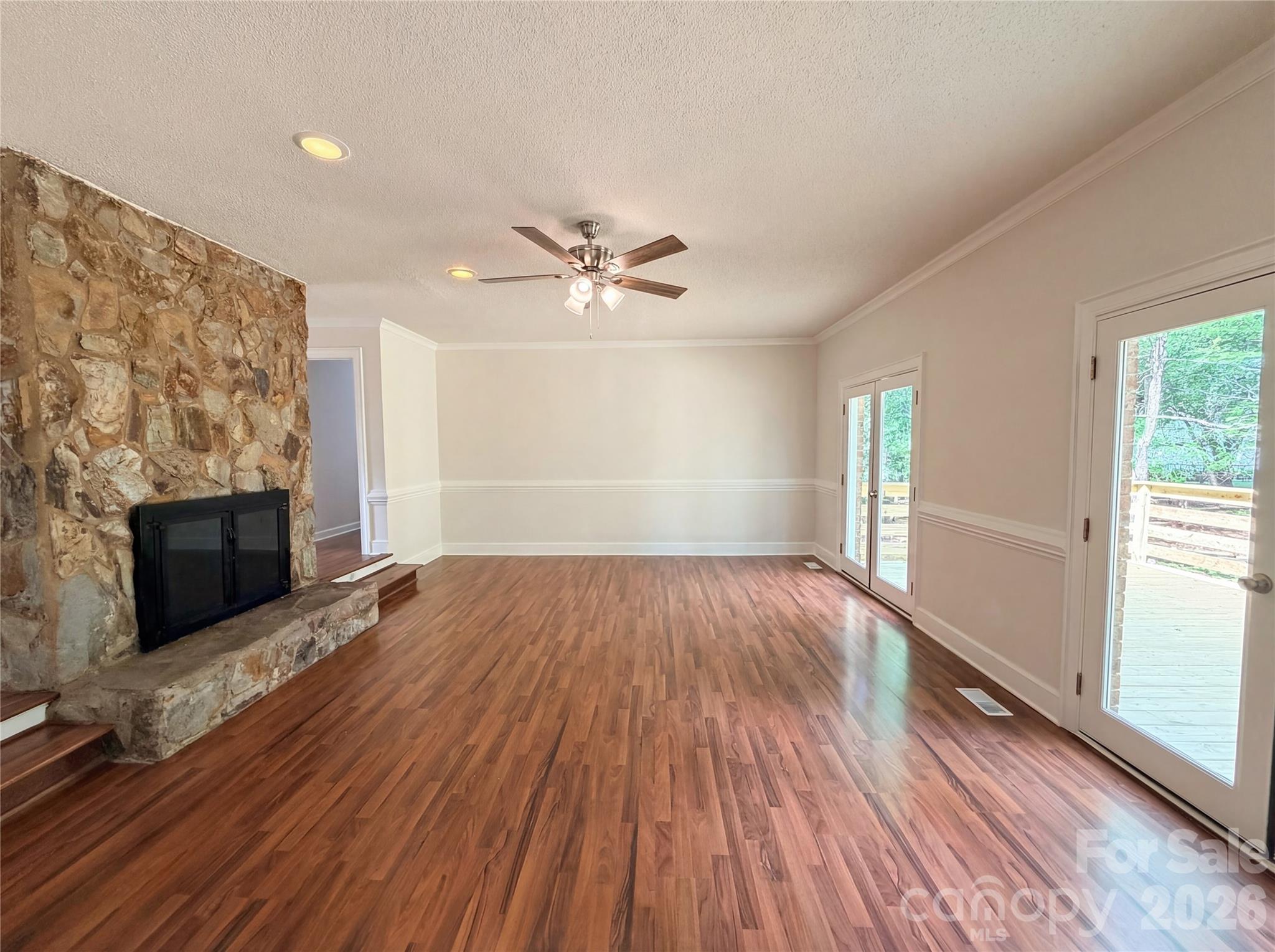 6024 Dovefield Road Charlotte, NC 28277 - Photo 4 of 17 wooden floor in an empty room with a fireplace