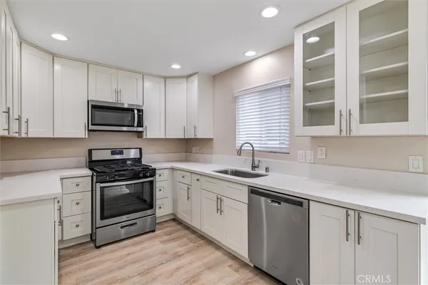 a kitchen with stainless steel appliances granite countertop a stove a sink and a microwave