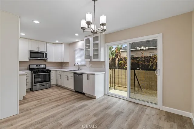 a kitchen with stainless steel appliances granite countertop a refrigerator a stove a sink and a oven