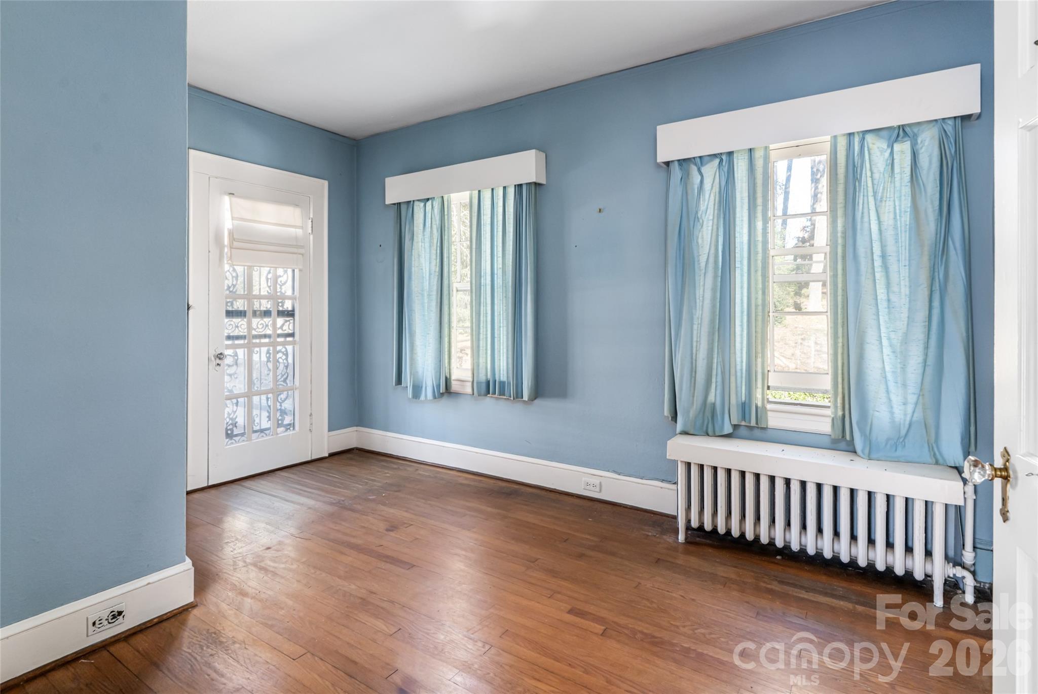 325 Vanderbilt Road Asheville, NC 28803 - Photo 28 of 48 an empty room with wooden floor and windows