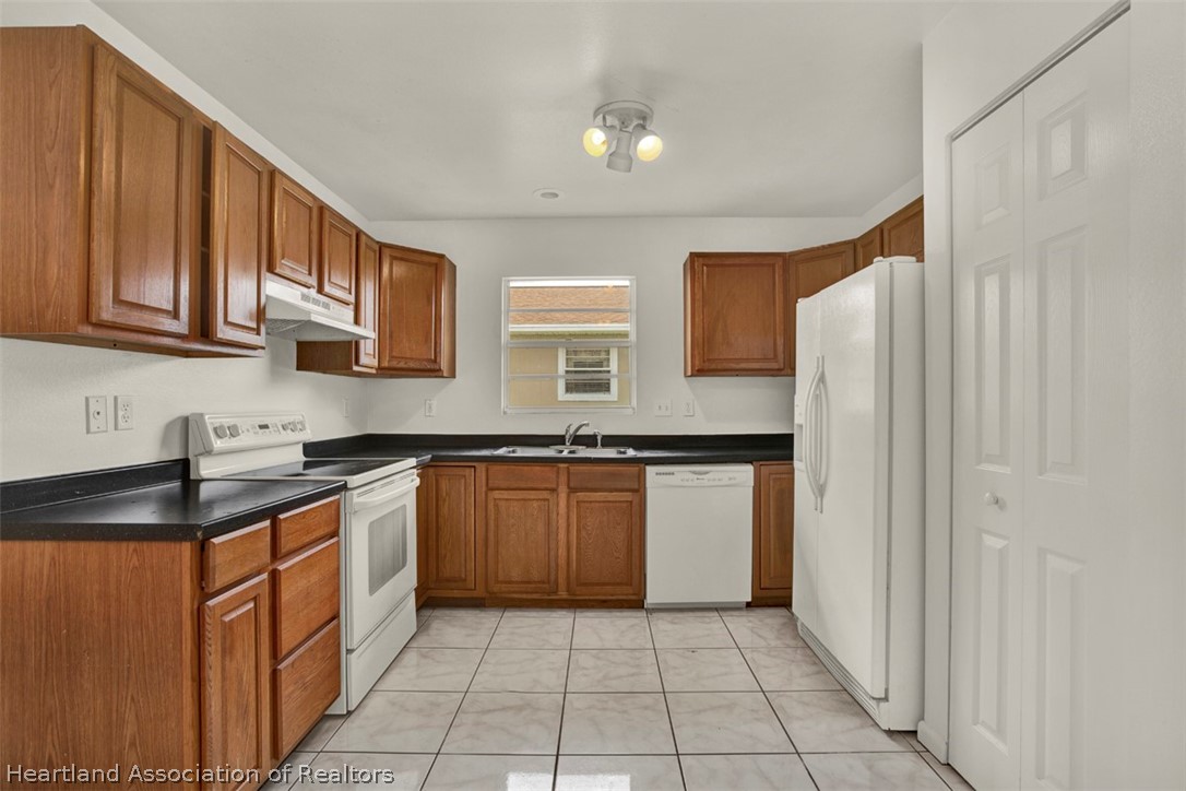 3533 Cemetery Road Sebring, FL 33870 - Photo 4 of 21 a kitchen with stainless steel appliances granite countertop a stove a sink and a refrigerator